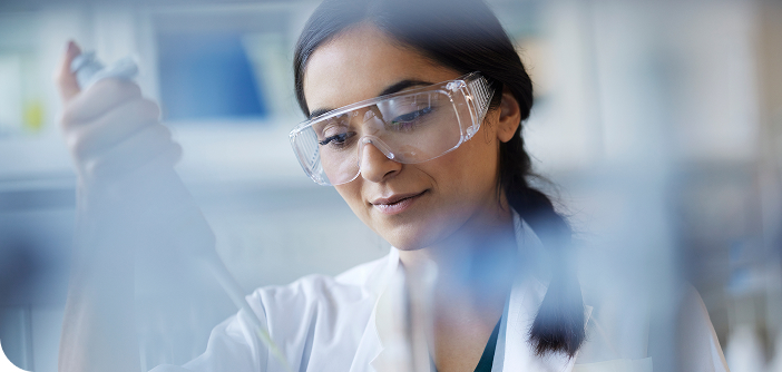 Female scientist in a lab conducting research, contributing to cancer resources development.